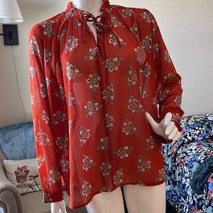 Long sleeved rust colored blouse with flowers.